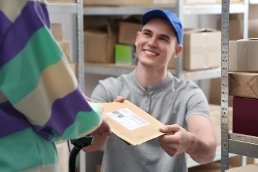 Raktári környezetben papíralapú postázó tasak átadása kézbesítéskor.