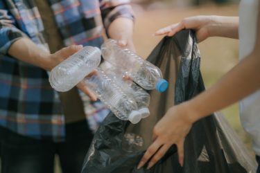Használt műanyag palackokat helyeznek egy zsákba visszagyűjtés céljából.