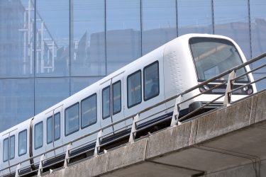 Modern metrószerelvény egy magasvezetésű városi pályaszakaszon.