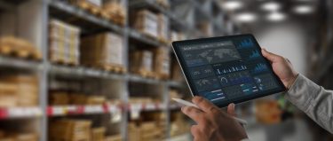 Egy raktári szakember digitális adatokat elemez, amelyek segítik a logisztikai folyamatok optimalizálását.